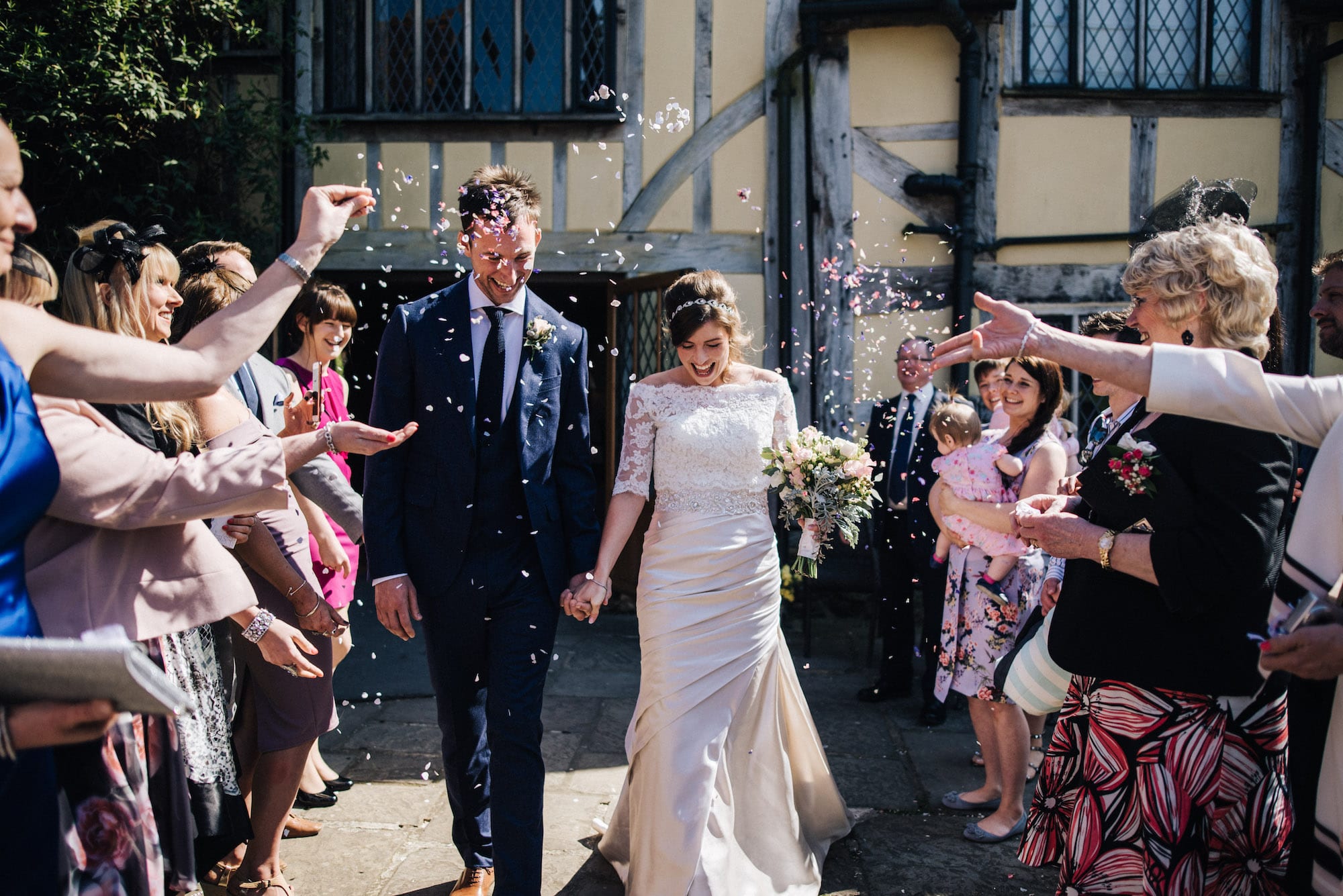 Spring confetti shot of Bride and Groom exiting rustic barn