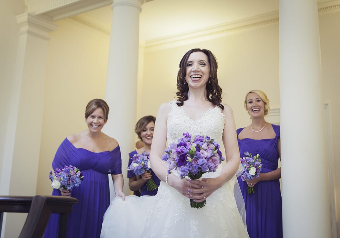 bride with bridesmaids walking down Botleys Mansion staircase