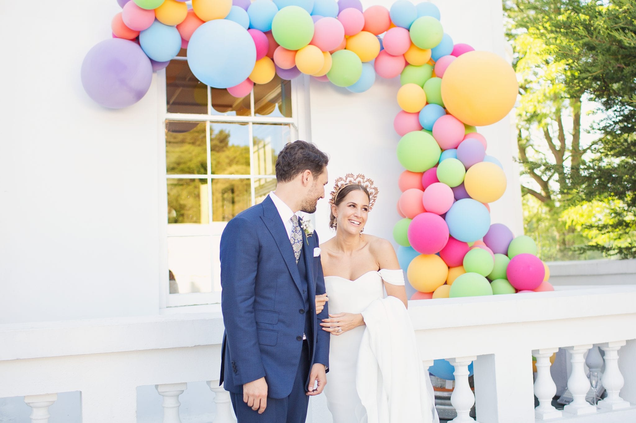 newlyweds with colour balloon arch multicolour balloons