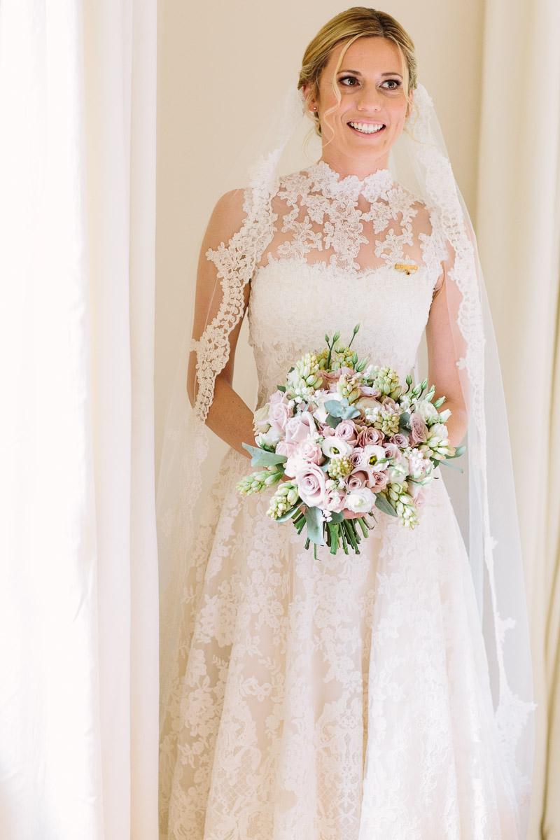 lace bridal gown with long cathedral lace edge veil and bridal bouquet